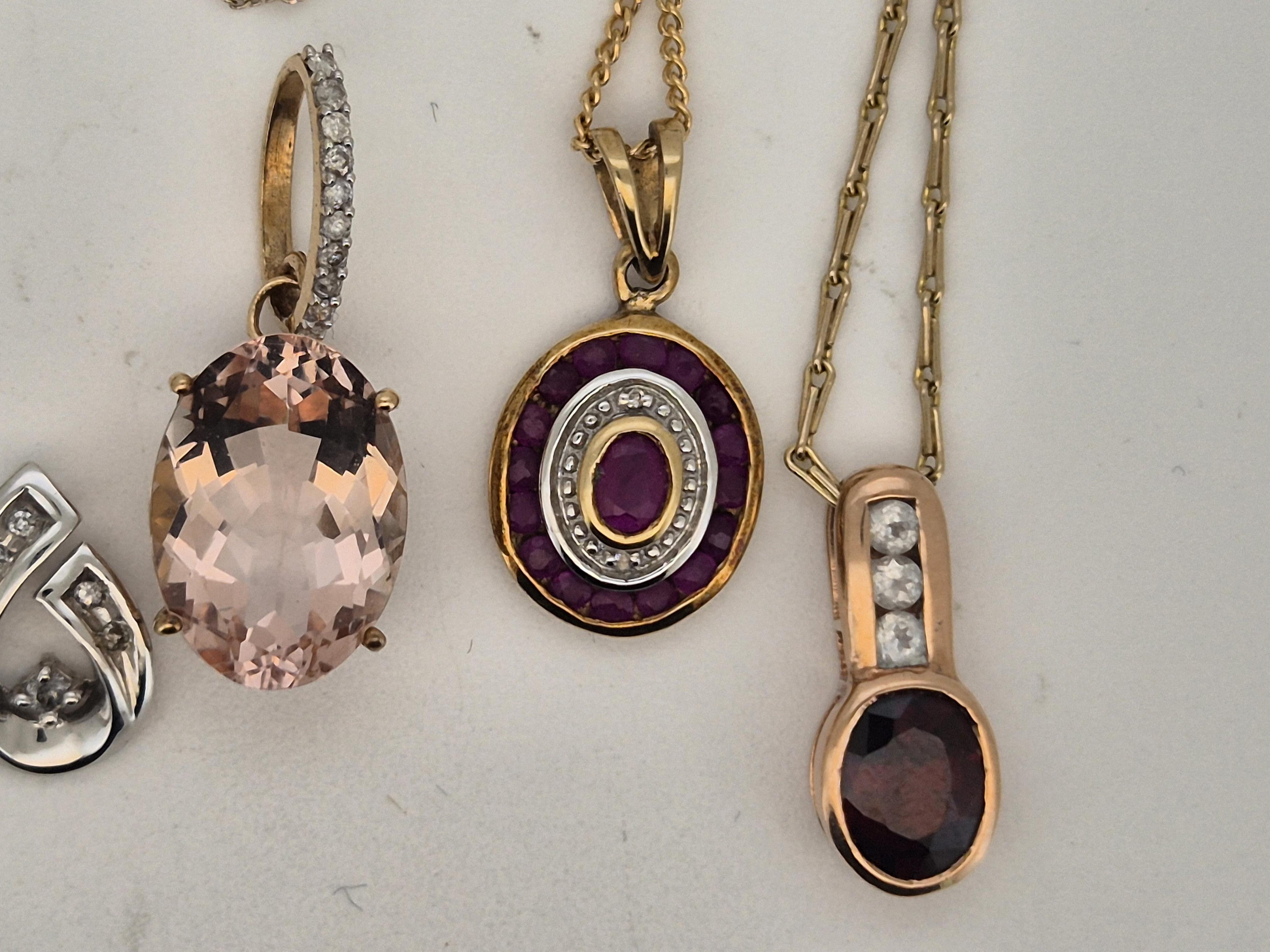 A modern 10k white metal and diamond chip set scroll pendant, 12mm, on a 10k white metal chain, (knotted with a 375 chain), together with three other modern 9ct and gem set pendants, including cultured pearl, all with 9c